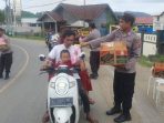 Polisi Bagikan Takjil kepada Pengendara yang Melintas di Depan Mapolsek Seteluk